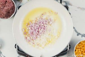 sauteing onions and butter to make pastel de chocolo corn and beef casserole