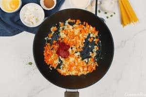 sauteeing vegetables to make pastitsio greek beef pasta bake