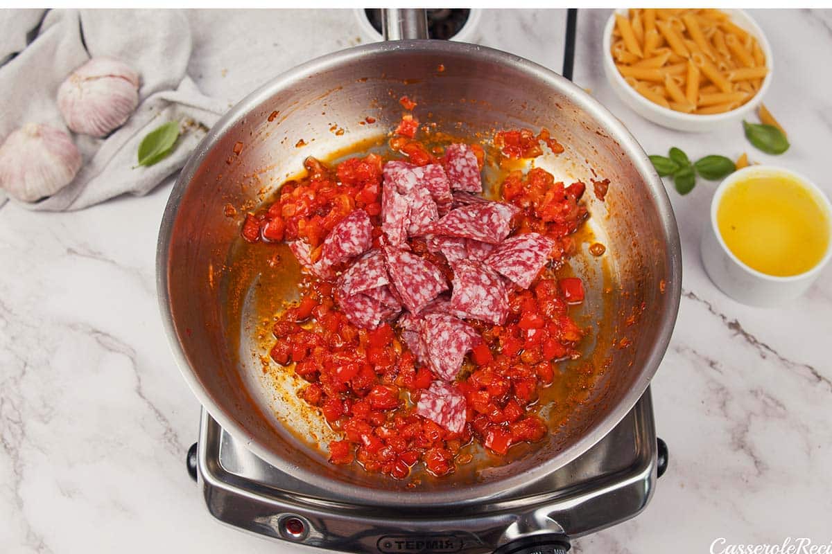 onion, pepperoni and other ingredients being sauteed to make pepperoni pasta bake