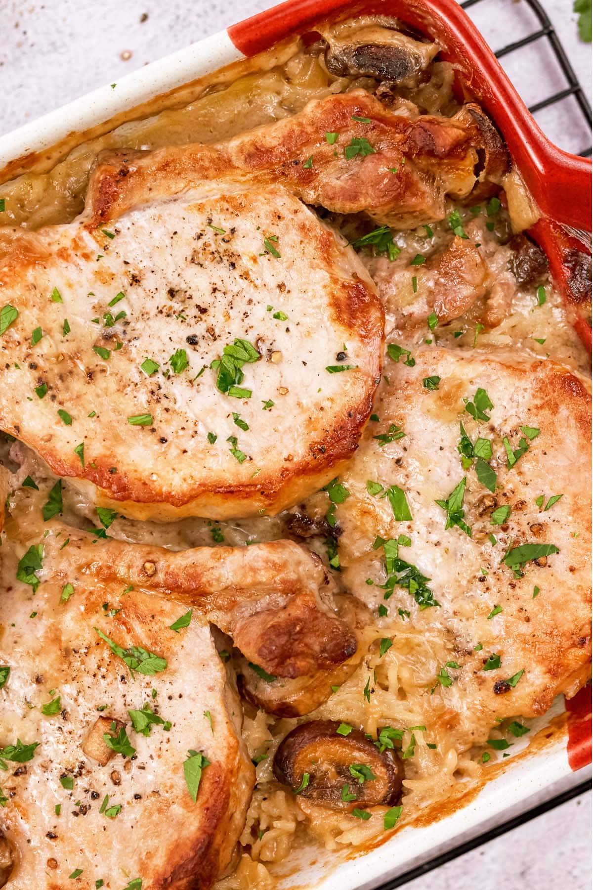 closeup of a baking dish of pork chops and rice casserole