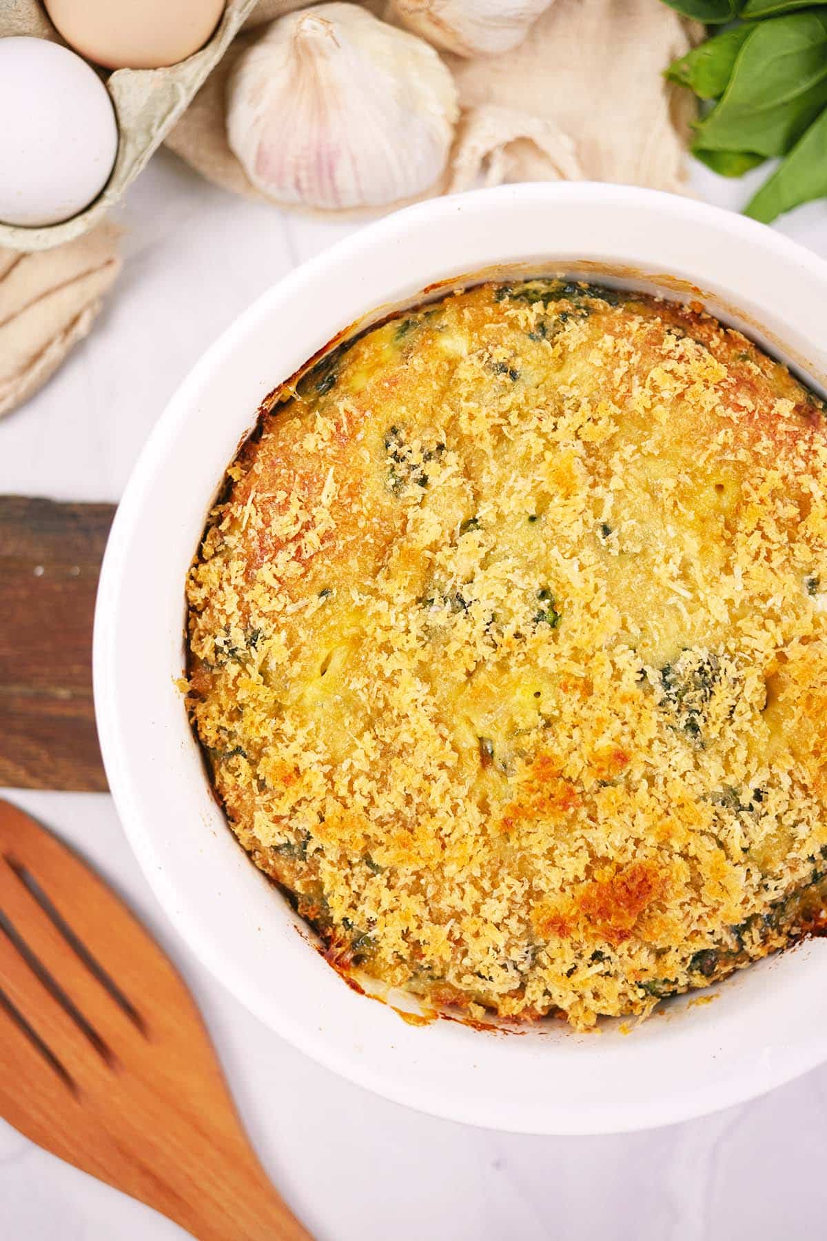 overhead view of a baking dish of spinach casserole with feta ready to serve