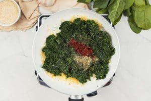 combining spinach with other ingredients to make the filling for spinach casserole with feta