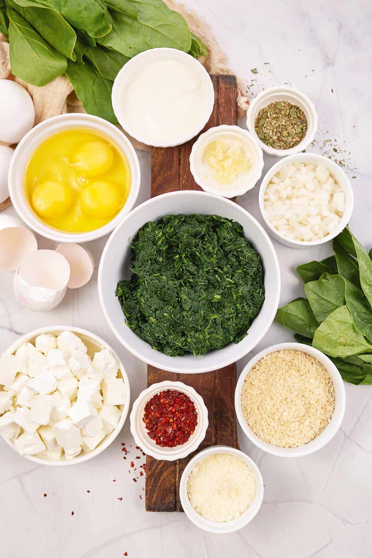ingredients to make spinach casserole with feta laid out on a table