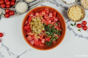 tomatoes and spices being combined to make tomato casserole