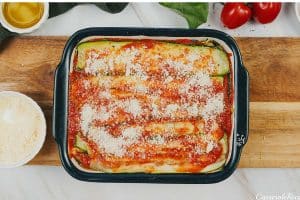 parmesan sprinkled over layered ingredients to make Zucchini Parmesan