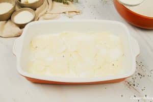 layering ingredients in a baking dish to make Cacio e Pepe Casserole