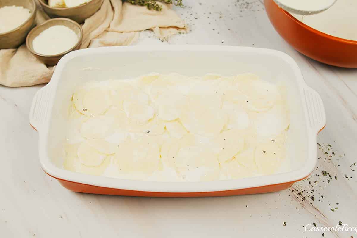 layering ingredients in a baking dish to make Cacio e Pepe Casserole