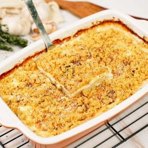 spatula lifting a serving of Cacio e Pepe Casserole from a baking dish