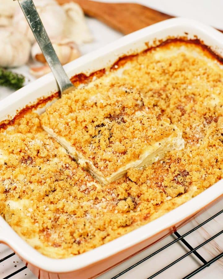 spatula lifting a serving of Cacio e Pepe Casserole from a baking dish