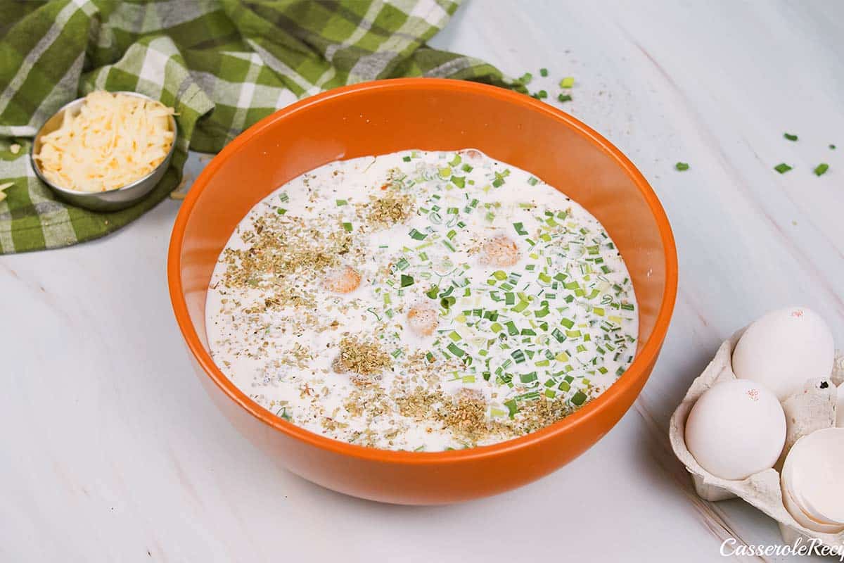 combining ingredients to make Cheesy Sausage Breakfast Casserole