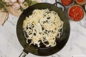 onions being sautéed to make Tomato and Houllimi Bake