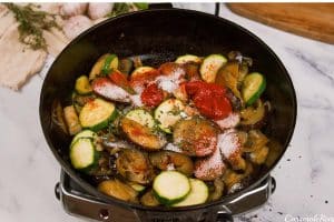 combining ingredients to make Tomato and Houllimi Bake