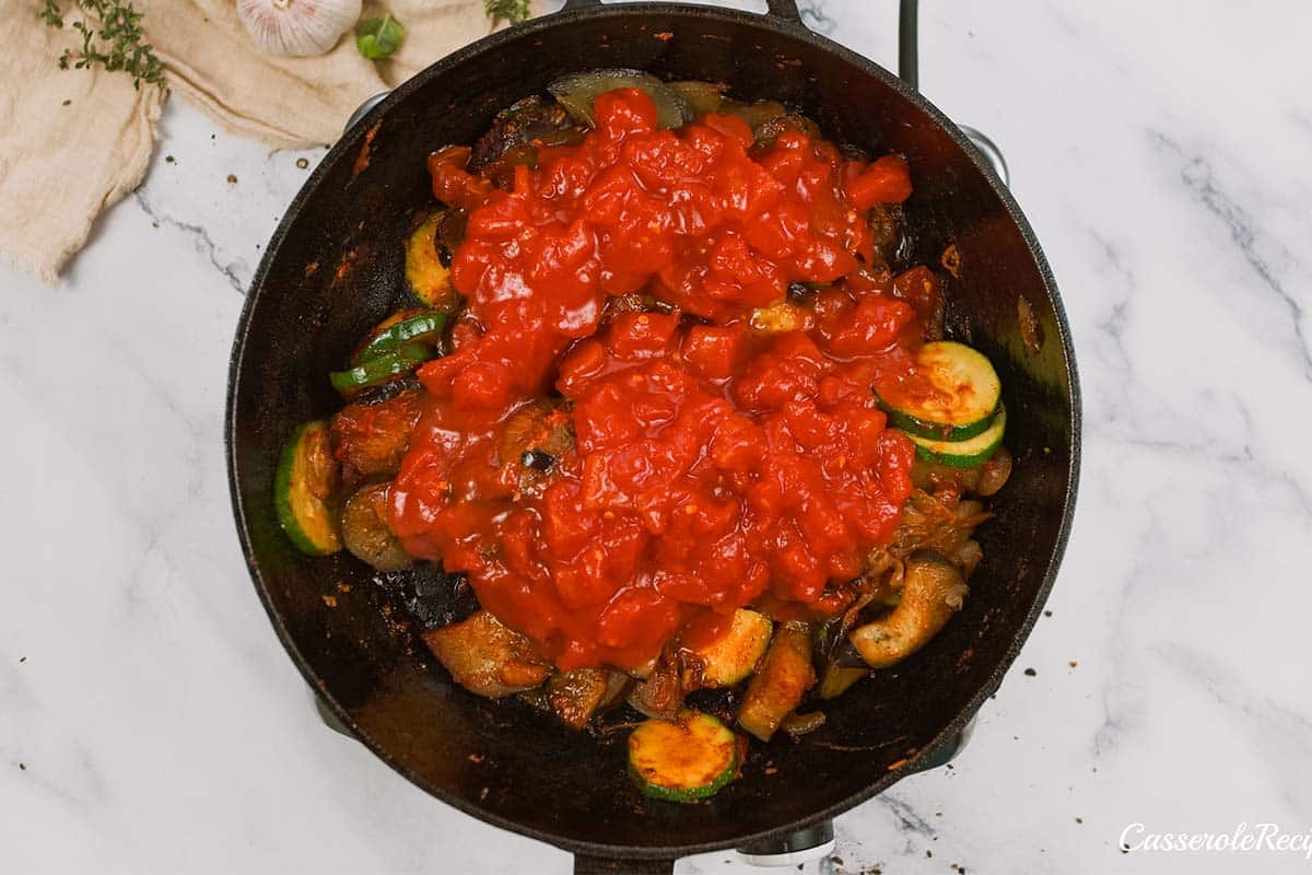 layering ingredients in a casserole dish to make Tomato and Houllimi Bake