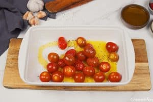 tomatoes and olive oil in a baking dish to make baked feta pasta