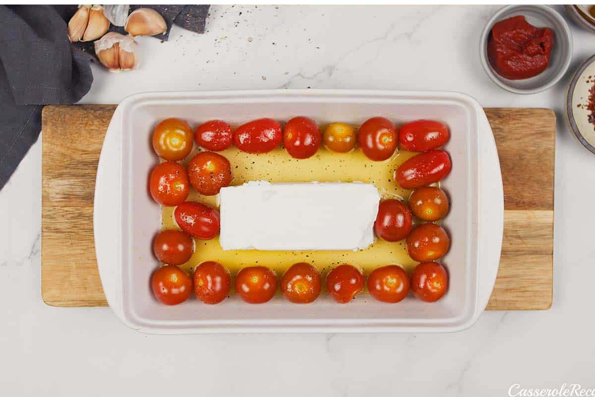 olive oil, tomatoes and feta cheese in a baking dish to make baked feta pasta