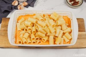 combining cooked pasta with other ingredients to make baked feta pasta