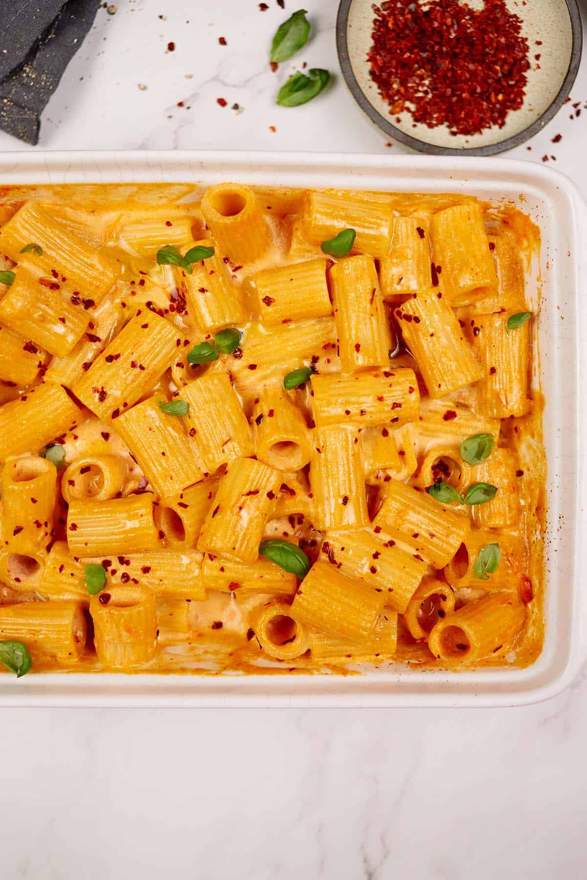 casserole dish of baked feta pasta on a table with other ingredients