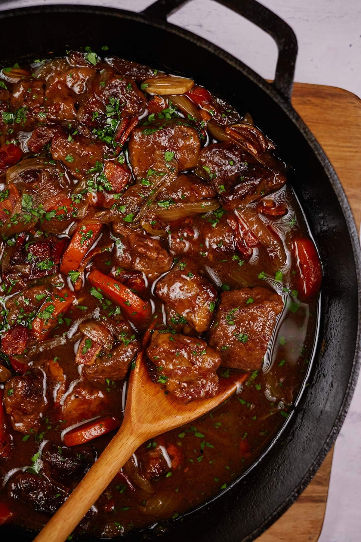 spoon scooping up a serving of the best beef casserole recipe from a cast iron skillet