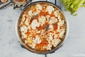 mixed ingredients in a pot to make buffalo cauliflower and chickpea casserole