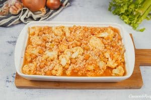 final step of putting filling for buffalo cauliflower and chickpea casserole before baking