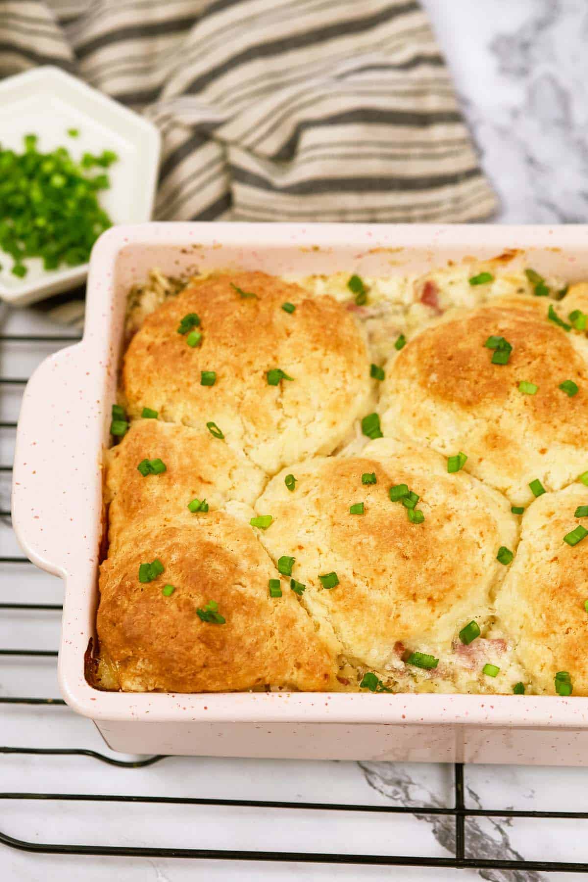 chicken cordon bleu bubble-up bake in a casserole dish on a wire rack to cool