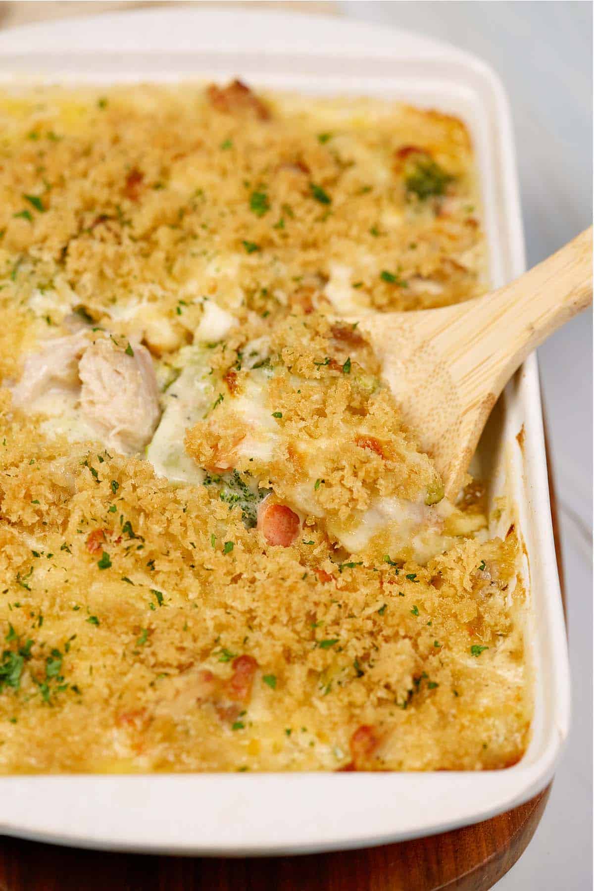 spoon scooping up a serving of chicken divan from a baking dish