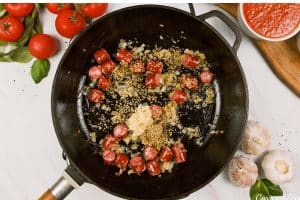 sauteing herbs and spices to make chorizo gnocchi bake