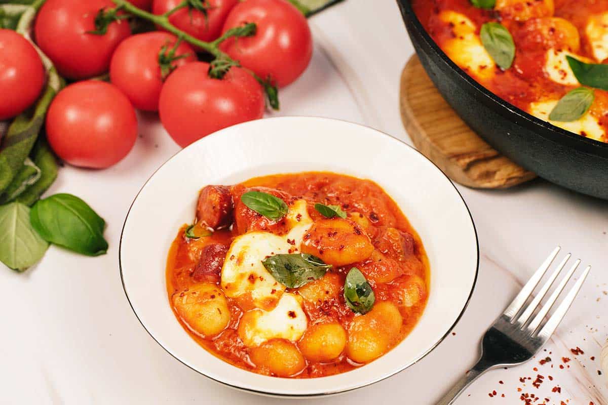 bowl filled with a serving of chorizo gnocchi bake on a table