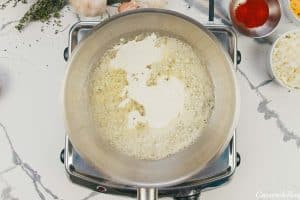 sauce being made in a sauce pan for creamy cauliflower casserole