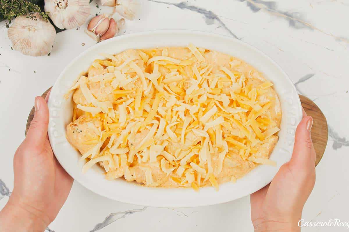 final step of covering the creamy cauliflower casserole with cheese prior to baking