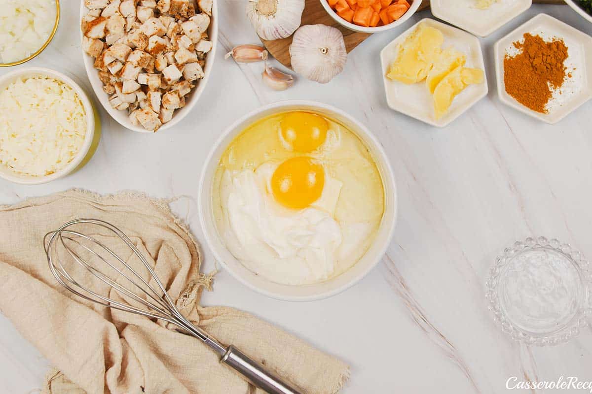 eggs and other ingredients being combined to make the topping for curried chicken and grits casserole