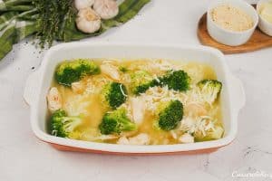 combining ingredients in a casserole dish to make garlic cheddar chicken bake