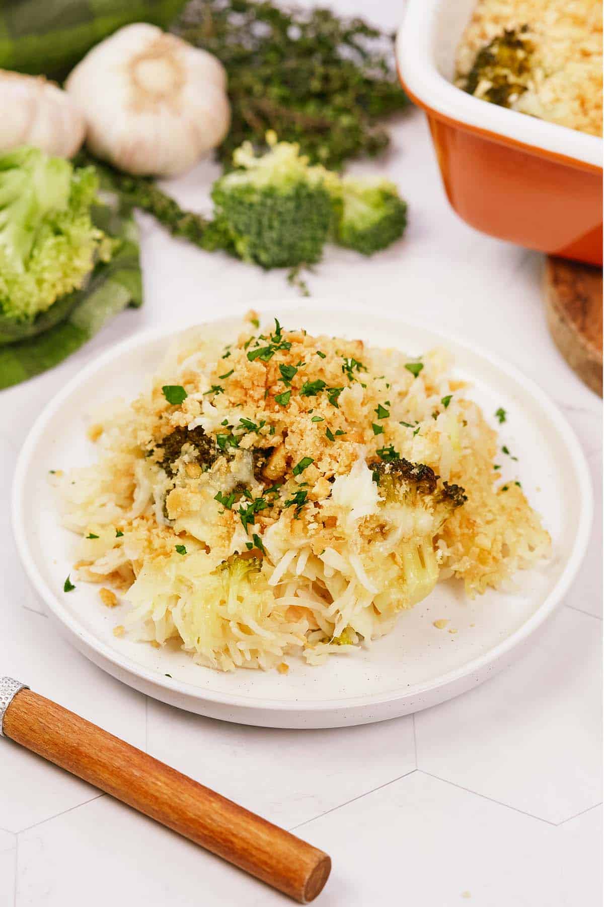 plate of garlic cheddar chicken bake on a table with ingredients in the background