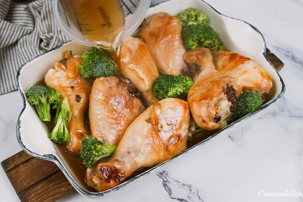 pouring sauce over chicken and broccoli to make miso chicken bake