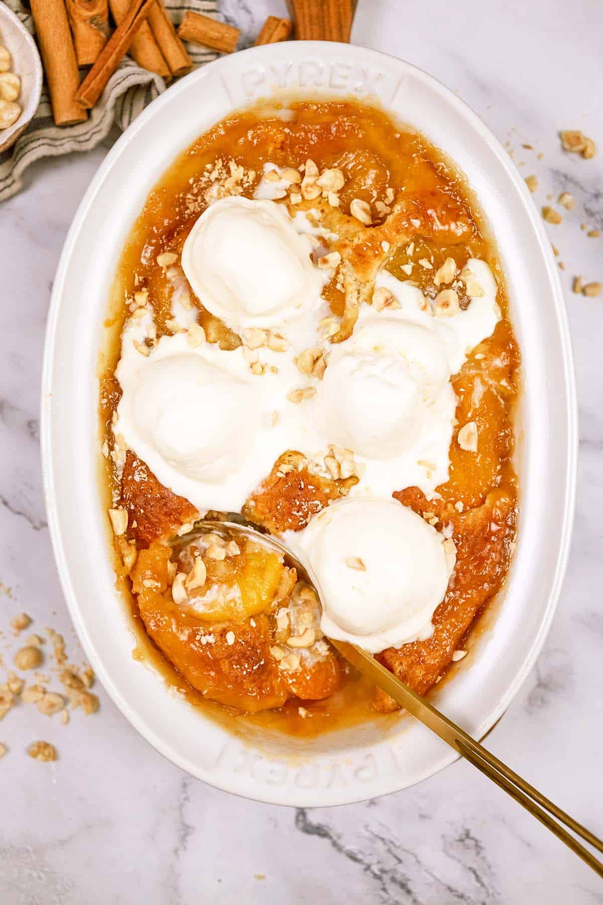 baking dish of peach, almond and caramel self-saucing pudding