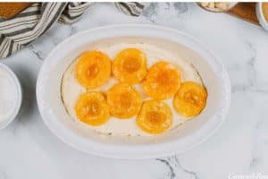 layering ingredients to make peach, almond and caramel self-saucing pudding