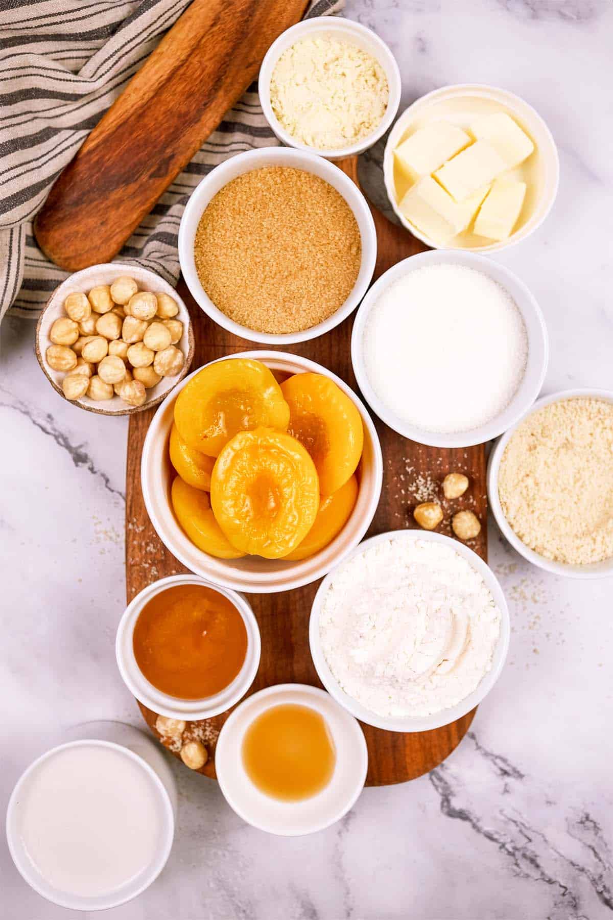 oerhead view of ingredients to make peach, almond and caramel self-saucing pudding on a table