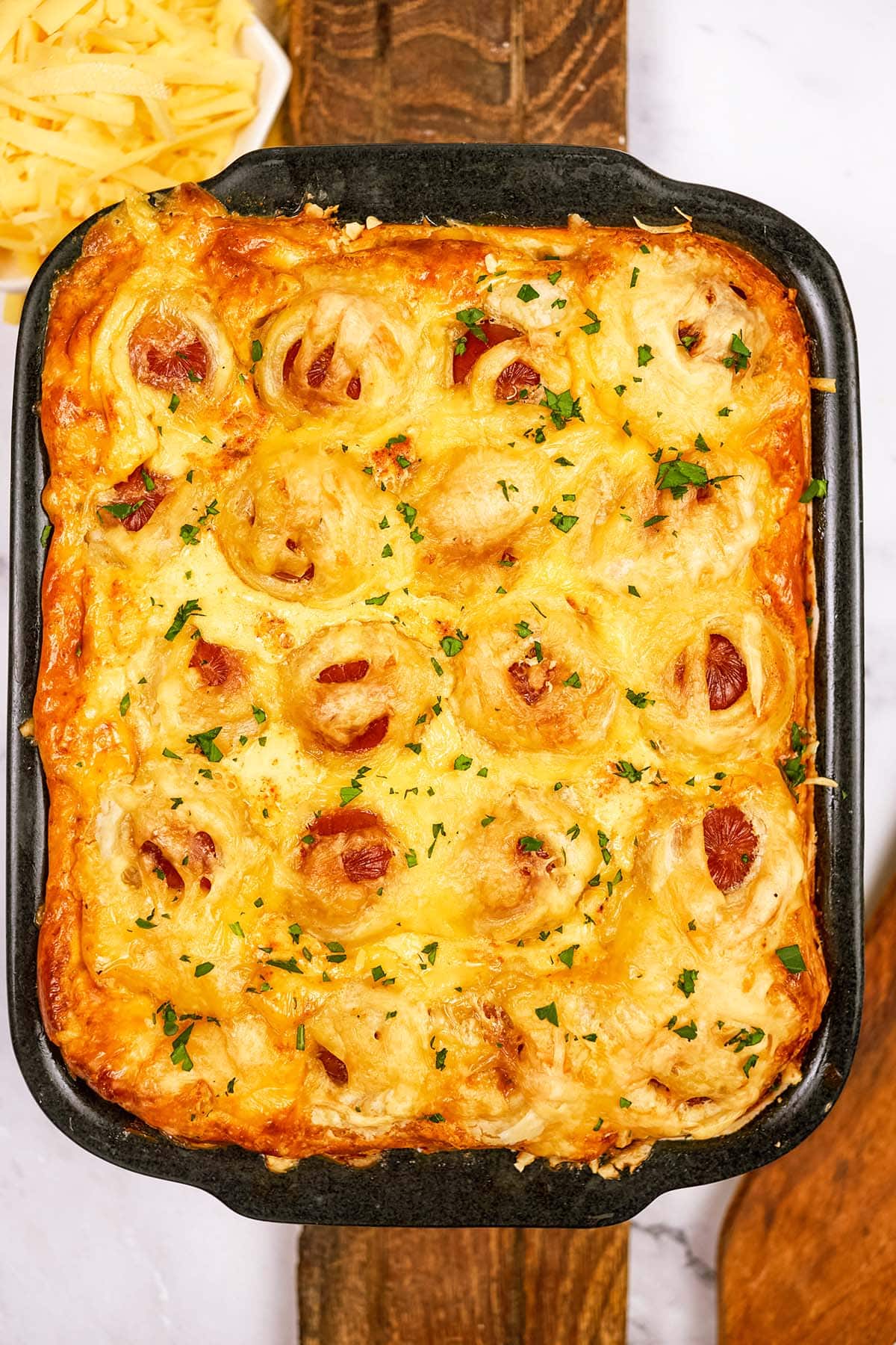 baking dish filled with pigs in a blanket breakfast casserole ready to serve