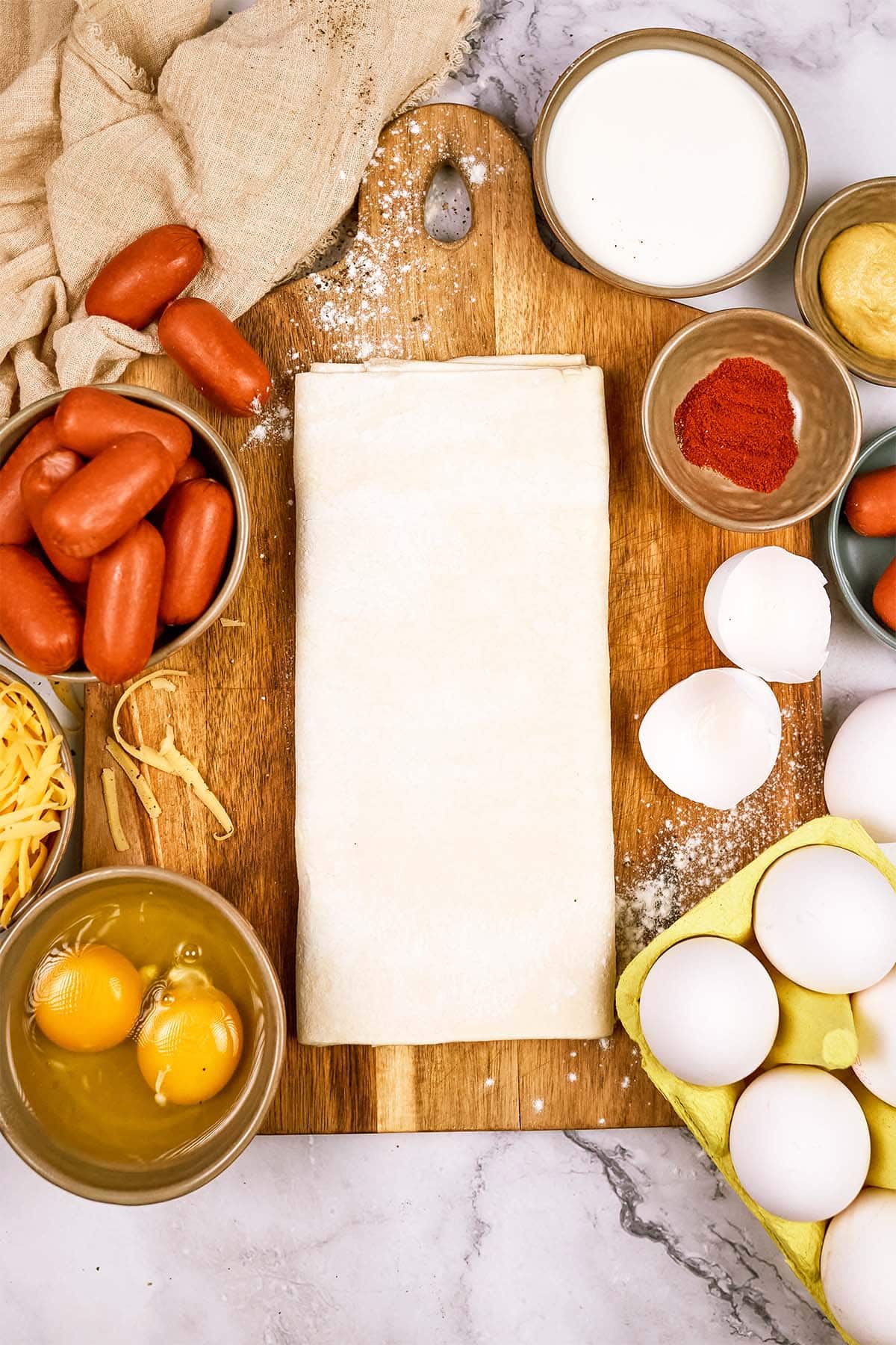 ingredients to make pigs in a blanket breakfast casserole laid out on a table