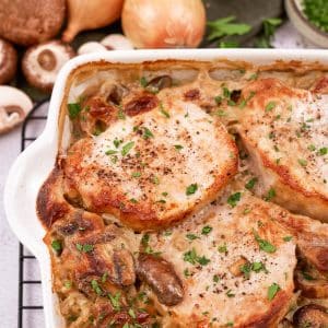 baking dish of pork chops and rice casserole on a table with other ingredients