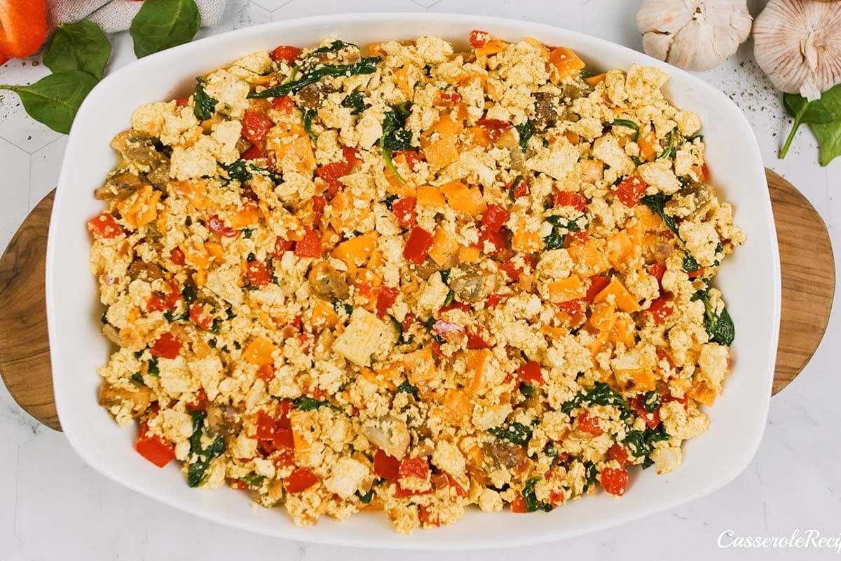 final step of topping the bake with a mixture to make a scrambled tofu casserole before baking