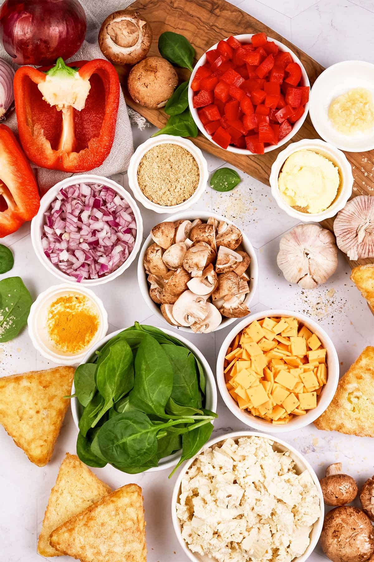 overhead view of ingredients to make a scrambled tofu casserole laid out on a table