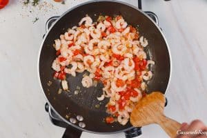 cooking shrimp and veggies together to make shrimp and grits bake