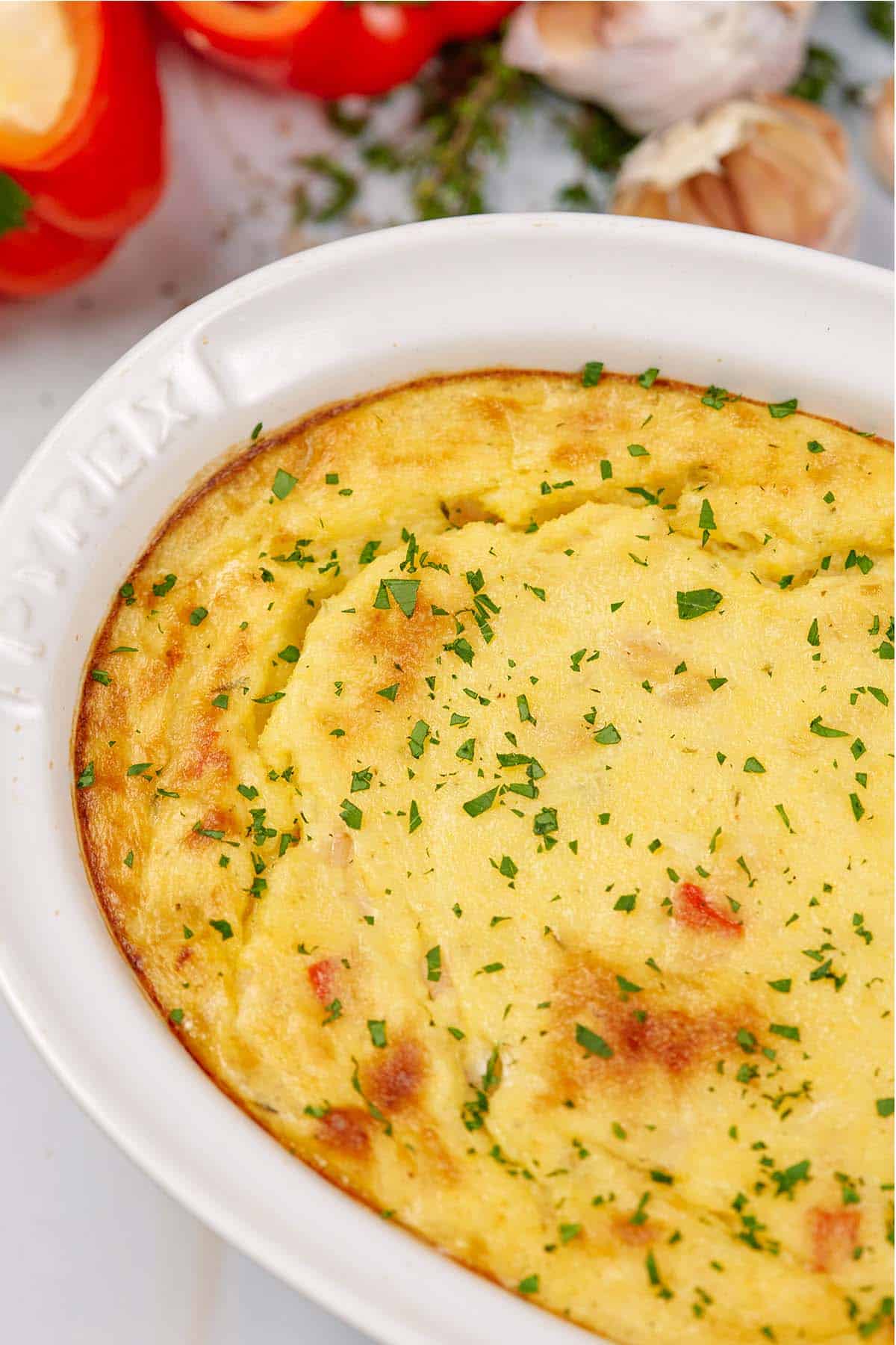 baking dish of shrimp and grits bake on a table with extra ingredients