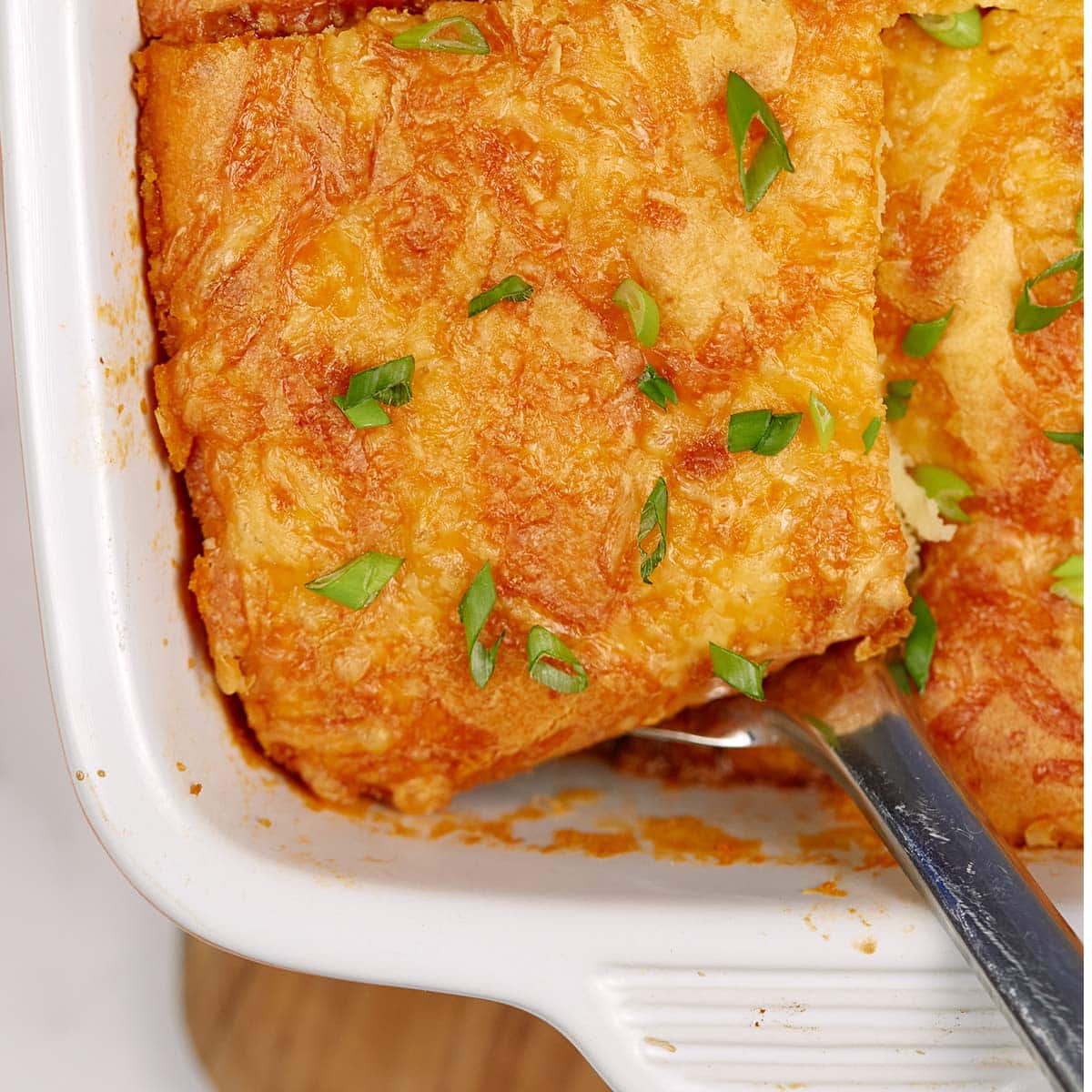 spoon scooping out a serving of sloppy joe casserole from a baking dish