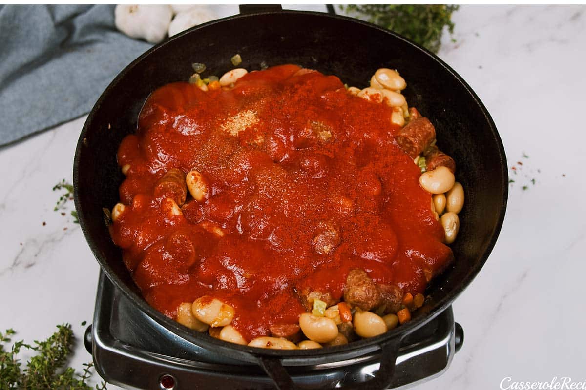 ingredients being combined in a pan to make vegan sausage casserole