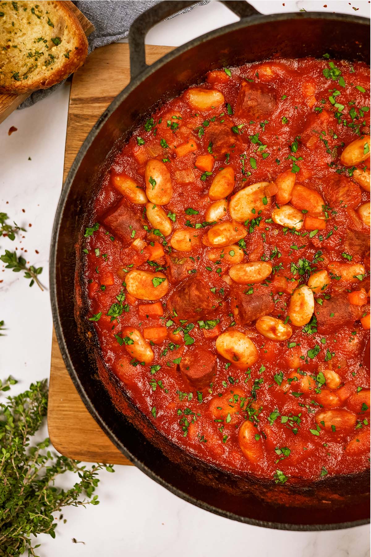 baking dish filled with vegan sausage casserole on a table with ingredients surrounding