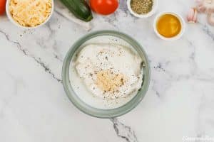 combining ingredients to make a sauce for zucchini tomato casserole