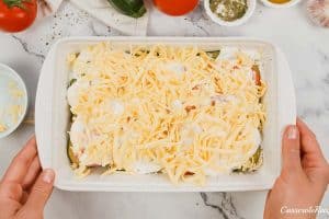 final step of topping the casserole with cheese prior to baking in order to make zucchini tomato casserole