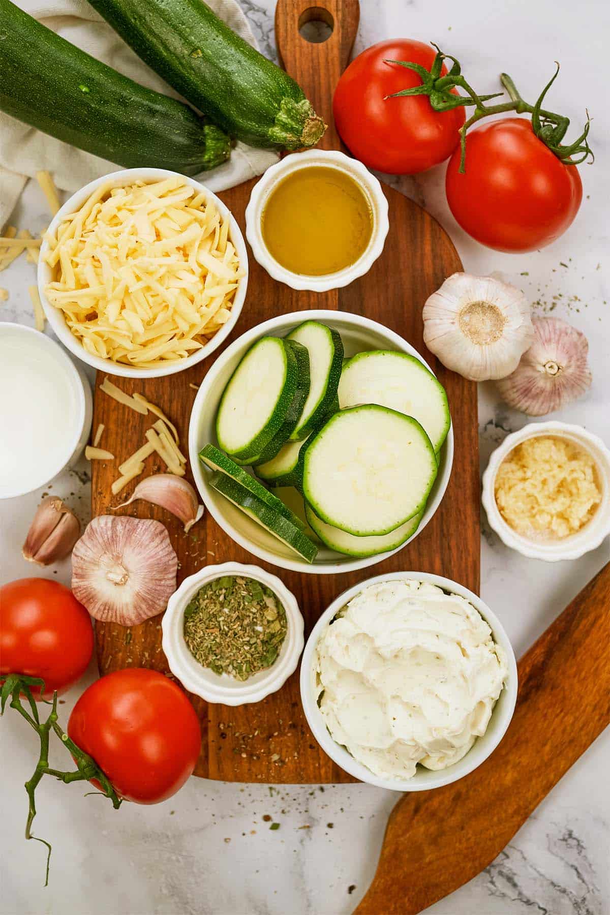 overhead view of the ingredients to make zucchini tomato casserole on a table